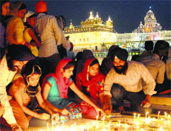 Devotees light candles on the premises of the Golden Temple to celebrate the birth anniversary of Guru Ram Dass in Amritsar on Thursday. Photo: Vishal Kumar