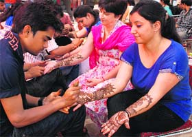 Artists apply henna on the hands of women ahead of Karva Chauth in Sector 7, Panchkula, on Thursday.