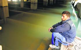 still flooded: A man in the basement of an under-construction hotel which is still submerged on the Residency Road in Srinagar on Thursday.