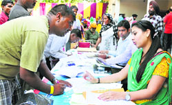 Slum dwellers fill in papers to avail loans at Leisure Valley in Ludhiana. Tribune Photo: Himanshu Mahajan