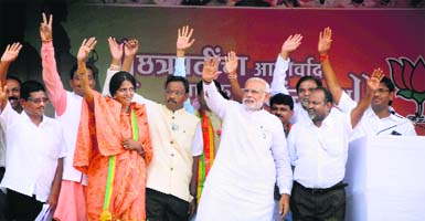 PM Narendra Modi, along with BJP leaders, waves to the crowd during an election rally in Baramati, Maharashtra, on Thursday. He criticised the Congress and the NCP over corruption in the state.