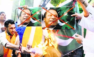 Hindu Sena activists burn Pakistan PM Nawaz Sharifs photographs in front of the Pakistan High Commission in New Delhi on Thursday. 