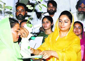 Union Minister Harsimrat Badal hands over a certificate to a woman after completion of her tailoring course in Fazilka