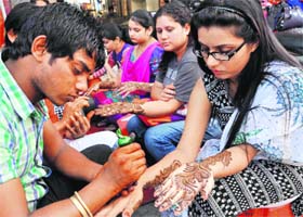 Colours of henna: Ladies get their hands decorated with mehndi for the Karva Chauth festival at Paltan Bazaar in Dehradun on Thursday