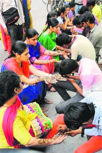 Girls get henna applied on their hands on the eve of Karvachauth in Bathinda on Friday. 