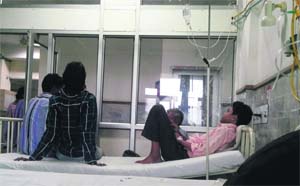 Attendants sit on a patient's bed at the GMCH, Sector 32, in Chandigarh