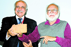 Pakistani author Fakir Aijazuddin presents a memento to Khushwant Singhs son Rahul Singh