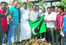 Members of Akhil Bharat Hindu Yuva Morcha burn the flag of Pakistan during their protest in Jalandhar on Friday.