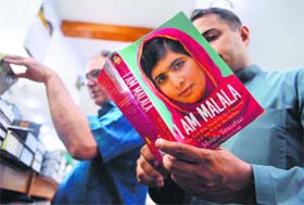 A Pakistani reads the autobiography of Malala Yousafzai at a bookstore in Islamabad on Friday.