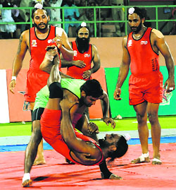 A Khalsa Warriors player tries to stop a Lahore Lions raider during their match in Bathinda on Friday.