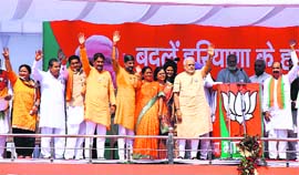 PM Narendra Modi and BJP candidates wave to the crowd in Fatehabad on Saturday.