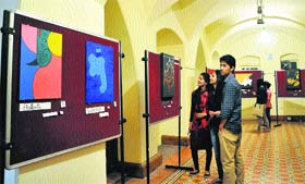 Visitors admire art works in a group painting exhibition at the Gaiety Theatre in Shimla.