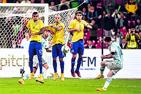Argentinas Messi shoots into a Brazilian wall during their friendly match in Beijing on Saturday. 