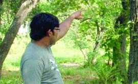 A youth shows the spot where the body of Kamleshvar was found hanging from a tree near Shantivan in New Delhi on Sunday.