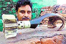 A villager displays a mortar shell fired from the Pakistani side at Arnia village in Jammu on Sunday