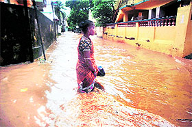 A woman wades through a waterlogged street after cyclone Hudhud caused heavy rains in Bhubaneswar on Sunday.