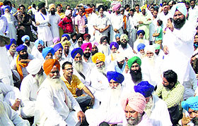 Congress workers sit on a dharna on the Amritsar-Bathinda road in Ferozepur on Sunday.