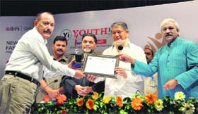 CM Harish Rawat and Cabinet Minister Dinesh Aggrawal give a Youth Icon Award to police officer GS Martolya at AMN Ghosh auditorium in Dehradun on Sunday