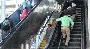 A passenger climbs the stairs of the dysfunctional escalator at the railway station in Amritsar on Sunday.