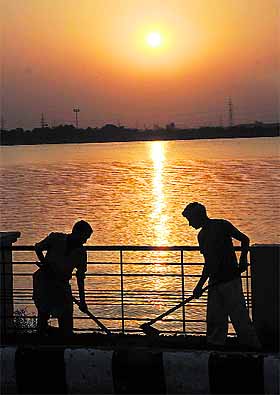 Labourers busy with their work at sunset besides Thermal lake in Bathinda on Monday. 