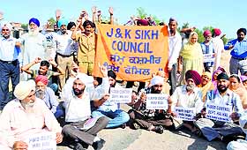 Members of the J&K Sikh Council along with residents of flood-hit area of Beli Charana protest in Jammu on Monday. 