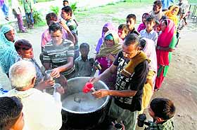 Villagers displaced by Pakistani firing line up to have tea at a relief camp in the Arnia sector of Jammu on Monday. 