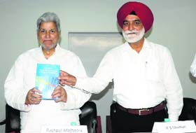 Centre for Research in Rural and Industrial Development Executive Vice-Chairman Dr Rashpal Malhotra (left) releases a book on Punjab economic in Chandigarh on Monday