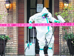 A health worker disinfects the entrance to the residence of 