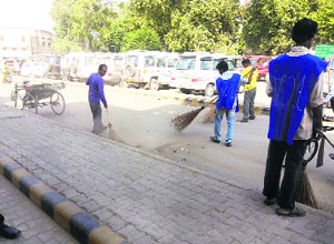 Volunteers of the NGO Voice of Amritsar clean a road in Amritsar.