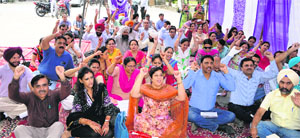 Members of the Punjab and Chandigarh College Teachers Union hold an agitation opposite Guru Nanak Dev University in Amritsar on Tuesday.