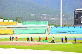The HPCA ground staff cover the pitch after rain in Dharamsala on Tuesday