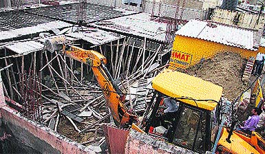 A JCB demolishes a building at Model Town in Jalandhar on Tuesday. 