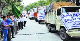 Trucks carrying relief material for flood victims being flagged off in Jammu.