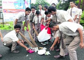 Students of The Indian Academy School remove garbage during a cleanliness drive at Kidduwala village in Dehradun on Tuesday