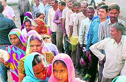 Voters wait in queues to cast their ballot at a polling booth in Sector 17, Panchkula, on Wednesday; and (right) Krishna (88) is all smiles as she shows the ink mark on her finger