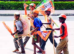 Ragpickers carry away BJP flags they collected from a counter in Sector 20, Panchkula, on Wednesday
