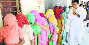 Women queue up to cast their votes as Congress candidate Randeep Surjewala passes by at the Kerok village pollling booth in Kaithal district on Wednesday; (right) this constable is on a fast on Hoi Ashtami in Kaithal Tribune photo