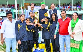 Health Minister Kaul Singh Thakur presents a trophy to the winning team in Mandi on Wednesday