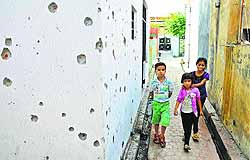 Children walk past a shelled wall in a border village in Samba district. The functioning of schools in the Jammu region has been disrupted due to Pakistani shelling