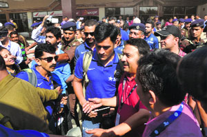 MS Dhoni surrounded by cricket fans