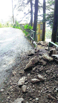 A view of the broken railing, along with boulders and sand dumped by a builder, on the Navbahar Ritz heritage walk road in Shimla.