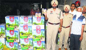 Policemen with a huge cache of spurious desi ghee in Jalandhar on Thursday