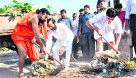 Yoga guru Ramdev along with Acharaya Balkrishan clean garbage near Divya Yog Mandir at Kankhal in Haridwar on Thursday as part of a cleanliness drive.