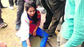 An injured woman in a state of shock at the place where a car fell in a deep gorge near Mussoorie on Thursday.