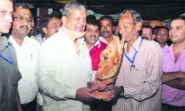 An artist hands over a terrcota Ganesh idol to the Chief Minister in Dehradun on Wednesday.