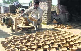 A worker prepares earthen lamps in Dehradun on Thursday as Divali approaches.