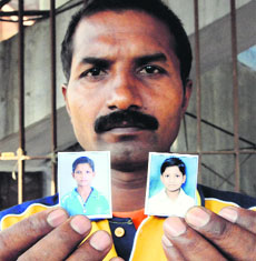 Ramesh Kumar shows the photogpraphs of his two sons, Rahul and Rohit, who went missing from the Majitha road area in Amritsar a few days ago.