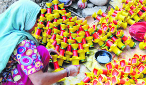 A woman craftsman paints earthen lamps ahead of Diwali in Amritsar.