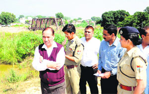 Chief Secretary Subhash Kumar inspects the site for a new cable bridge to be constructed for Ardh Kumbh at Jwalapur in Haridwar on Friday