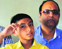 Victim Nitish with his father at the Dera Bassi police station. Tribune Photo: Nitin Mittal